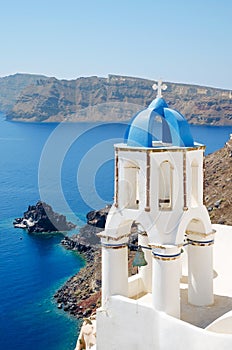 Classic view of white church with blue domes - Oia village, Santorini Island in Greece