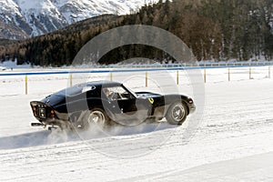 A classic vintage car on the frozen lake of St Moritz in winter