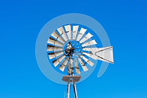 Classic vintage multi bladed wind pump, bladed rotor decorated with string lights