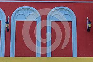 Classic white arch door pattern on the red wall background.