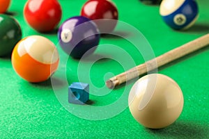 Classic white billiard ball on green table, closeup. Space for text