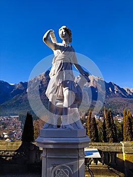 Classic white marble statuette Diana statue isolated on blue sky background. Scilpture of huntress