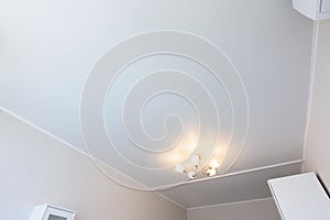 Classic white matte stretch ceiling in the interior of the bedroom