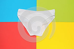 Classic white women`s panties on a colored background of four colors. Minimal concept of women`s underwear