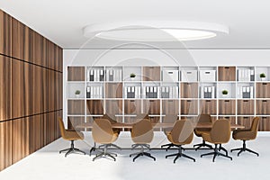 Classic white and wooden conference room interior with long table, binder bookcase and round lamp