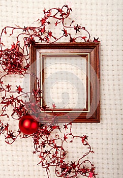 Classic wooden frame decorated with Christmas foil stars and red ball