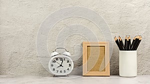 Classic wooden photo frame with a clock and a pencils in white coffee cup. - blank space for message and advertising.