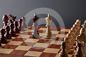 Classic Wooden Tournament chess set on black background. Two kings in centre of board other pieces lined up