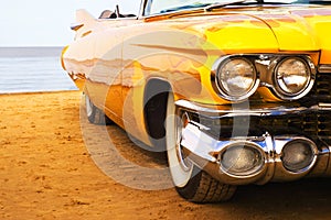 Classic yellow flame painted Cadillac at beach