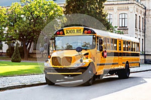 Classic yellow school bus with red stop sign standing on the road