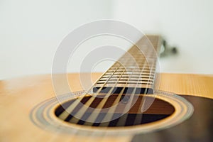 Classical acoustic guitar with vibrating strings on a white background