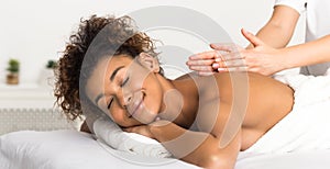 Classical back massage. African-american woman enjoying spa treatment