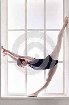 Classical Ballet dancer in split, ballerina at window sill