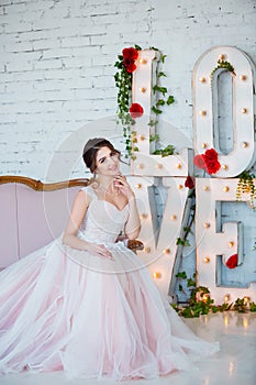 Classical beauty. Beautiful young woman with stylish brunette hair and elegant dress resting in luxury white classic