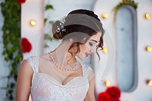 Classical beauty. Beautiful young woman with stylish brunette hair and elegant dress resting in luxury white classic