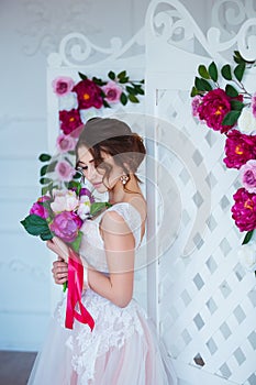 Classical beauty. Beautiful young woman with stylish brunette hair and elegant dress resting in luxury white classic