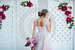 Classical beauty. Beautiful young woman with stylish brunette hair and elegant dress resting in luxury white classic