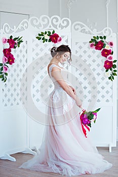 Classical beauty. Beautiful young woman with stylish brunette hair and elegant dress resting in luxury white classic