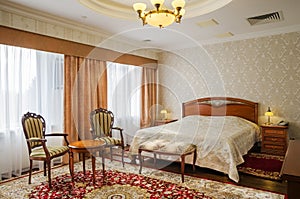 Classical bedroom with a large double bed, bedside tables, chairs