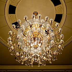 Classical crystal chandelier hanging on beautiful ceiling