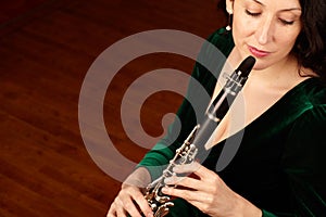 Classical culture. A beautiful clarinetist sitting and playing her instrument - copyspace.