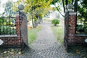 Classical design black wrought iron gate in a beautiful green garden