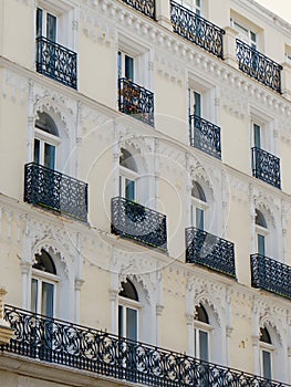 Classical facade with elegant balconies and windows decorated with stucco arches in central district of Madrid, Spain