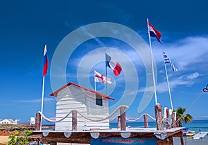 Classical Greek white Life guard house cabin with different flags on Ionian sea sand beach Greece Island Zakynthos. Beach architec