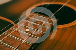 Classical guitar with broken string. Closeup of classical acoustic wooden guitar with a broken string