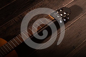 Classical guitar fretboard and machine head on a dark wood background