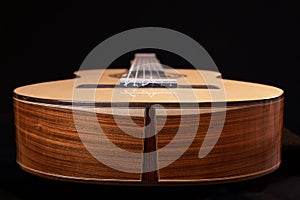 Classical guitar isolated on black background, view from the down side.