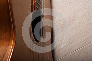 Classical guitar sound hole, fretboard and strings up close on a light wood background