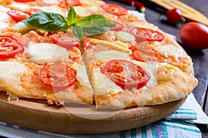 Classical Italian pizza `Margarita` with mozzarella, tomatoes, basil