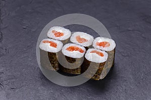Classical Japanese cuisine, sushi rolls with salmon on black sto