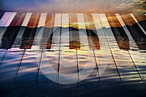 Classical music background photo double exposure of piano keys and sunset of a sea landscape creative