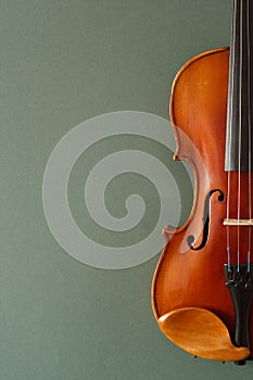 Classical music concert poster with brown color violin on dark green background with copy space