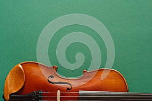 Classical music concert poster with brown color violin on dark green background with copy space