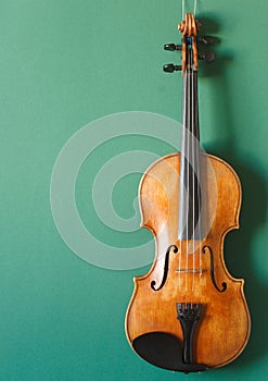 Classical music concert poster with brown color violin on dark green background with copy space