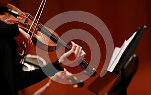 Classical music. Violinists in concert. Stringed, violinist. Closeup of musician playing the violin during a symphony photo