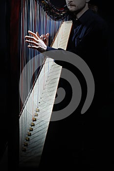 Classical musician hands playing harp strings