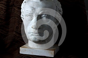 Classical plaster head bust on black background