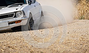 Classical rally racing car on dirt road