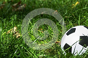 Classical soccerball on a green grass. Old soccer (football) ball on green field.