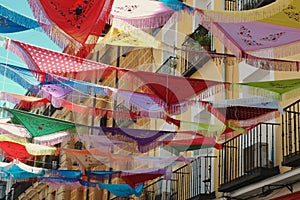 Classical Spanish shawls strung between the balconies outside on the street in La Latina district. Decorated ambient, festive mood