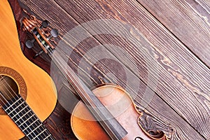 Classical violin and guitar on wooden background.