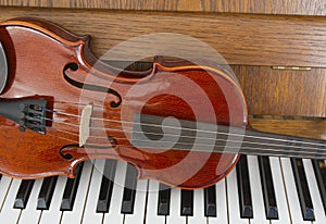 Classical violin on wooden piano keys. Classical violin on piano for music background concept. Holiday concert. Music concept