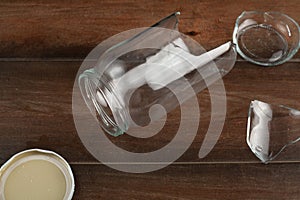 A classical wide mouth twist open glass jar has dropped and shattered into pieces