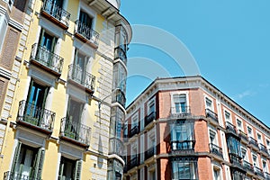 Classical yellow and red buildings with elegant metallic balconies in Chueca district downtown Madrid, Spain photo