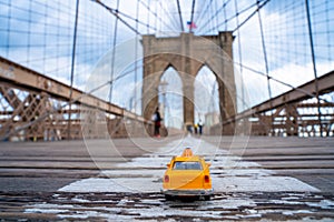 Classical yellow taxi model on an empty Brooklyn Bridge during lockdown in New York, because of the pandemic