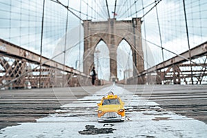 Classical yellow taxi model on an empty Brooklyn Bridge during lockdown in New York, because of the pandemic